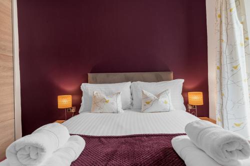 a bedroom with a large bed with white sheets and pillows at The Apartments Coniston in Coniston