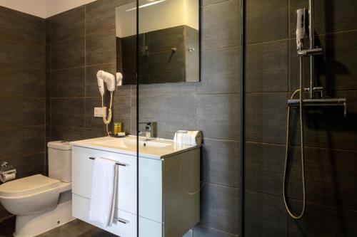 a bathroom with a toilet and a sink and a shower at Hotel LIVVO Budha Beach in Santa Maria