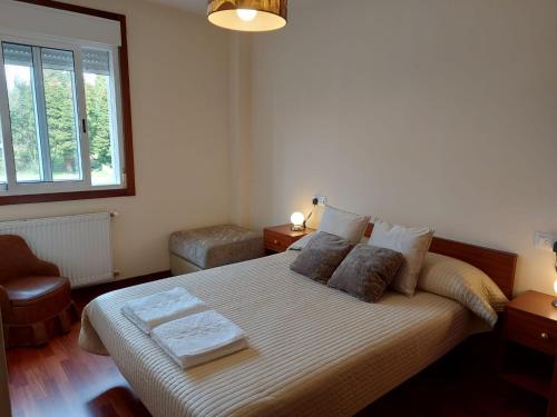 een slaapkamer met een groot bed met 2 kussens bij Apartamento Don Manuel 2 in Cuntis