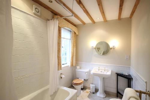 a bathroom with a toilet and a sink and a tub at Wethele Manor in Leamington Spa