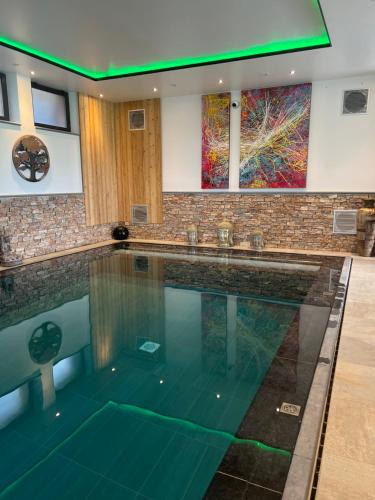 une grande piscine dans une maison dans l'établissement Le Domaine des Fagnes, à Sains-du-Nord
