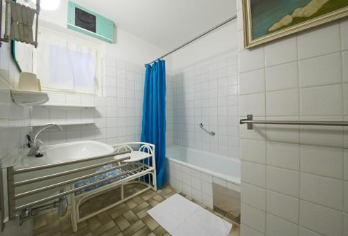 een badkamer met een bad, een wastafel en een douche bij Casa Vita Apartments in Saalbach Hinterglemm
