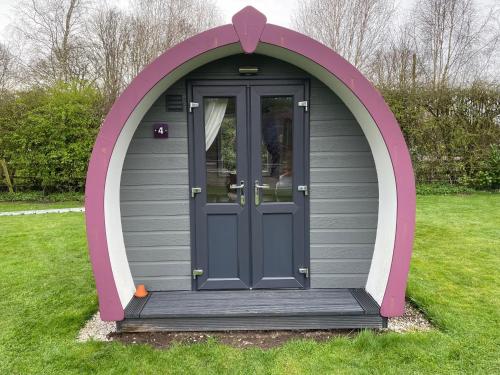 a gazebo with a door in the grass at Belle Vista Glamping & Camping in York