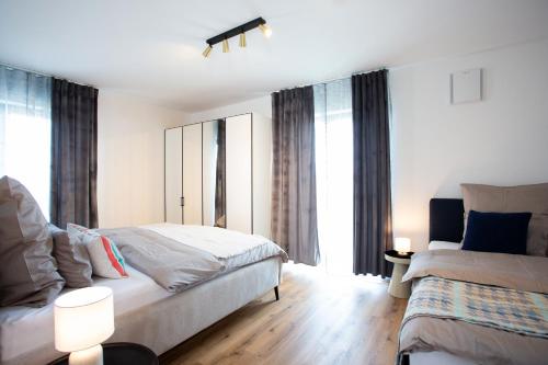 a bedroom with two beds and a window at Siebenschläfer Appartements in Eging am See