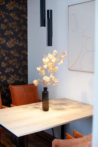 a vase with flowers on a wooden table at Siebenschläfer Appartements in Eging am See