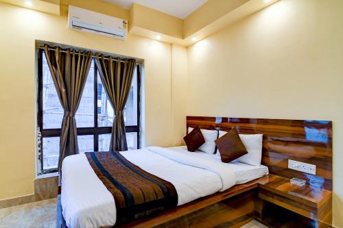 een slaapkamer met een bed en een raam bij Eco Corporate Inn 2 Rajarhat in kolkata