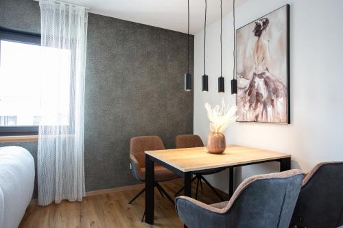 a bedroom with a table and chairs and a bed at Siebenschläfer Appartements in Eging am See