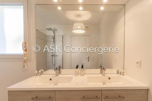 La salle de bains est pourvue d'un grand lavabo et d'un grand miroir. dans l'établissement Apartment BB with pool, close to the beach, shops, à Cavalaire-sur-Mer