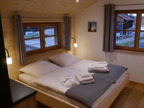 a bed in a room with two windows at Beim Winkel Max in Trauchgau