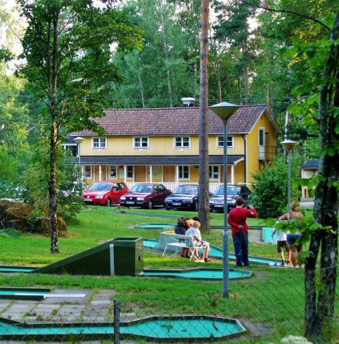 a group of people in a yard with a house at Sofielund Vandrarhem & Camping in Sala