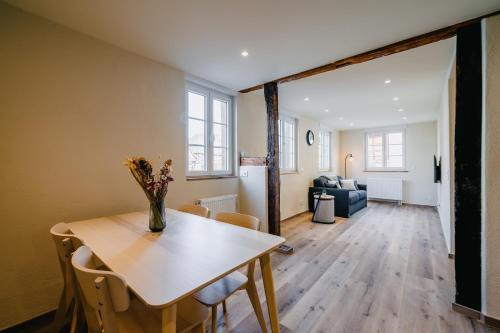 a dining room and living room with a table and chairs at Résidence Les Charmes in Boofzheim
