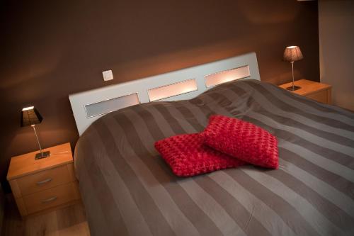 a red heart pillow sitting on top of a bed at B&B Innbrugas in Bruges