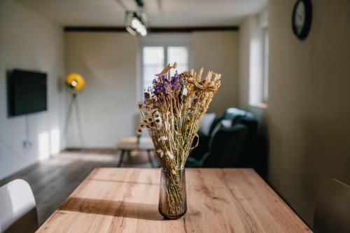 a vase filled with dried flowers sitting on a table at Résidence Les Charmes in Boofzheim