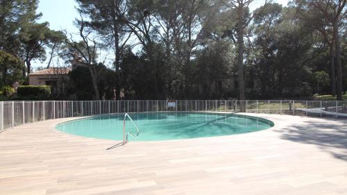 une piscine vide avec une clôture et des arbres dans l'établissement Apartment BB with pool, close to the beach, shops, à Cavalaire-sur-Mer
