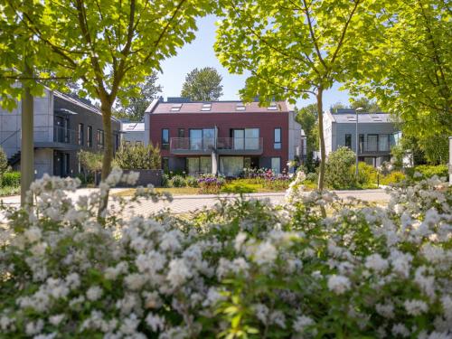 Un edificio con árboles y flores delante. en Rosevia Resort & Spa, en Jastrzębia Góra