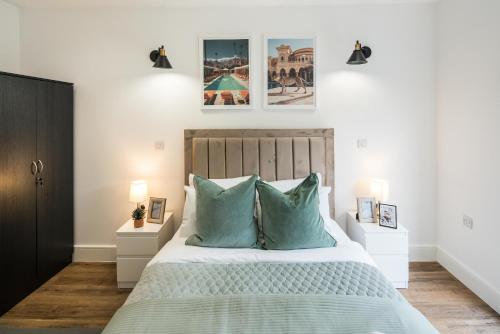 a bedroom with a large bed with blue pillows at BethnalGreen Apartments by Sleepy in London
