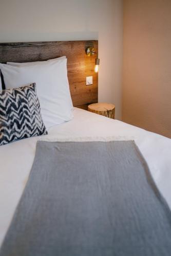 a bedroom with a white bed with a wooden headboard at Résidence Les Charmes in Boofzheim