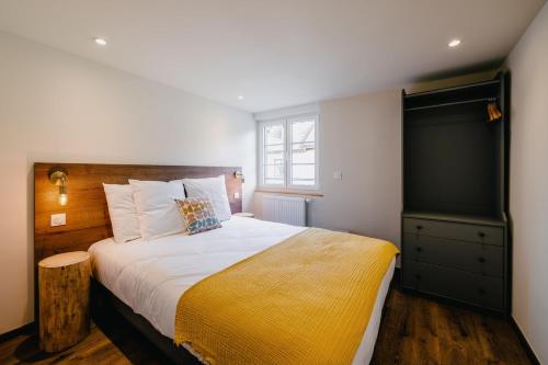 a bedroom with a large bed with a yellow blanket at Résidence Les Charmes in Boofzheim