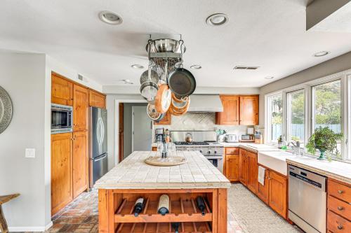 a kitchen with wooden cabinets and a island in it at Escondido Home Private Pool, 2 Grills and Fire Pit! in Escondido