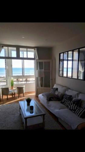 un salon avec un canapé et une table dans l'établissement Le panoramique, à Les Sables-dʼOlonne