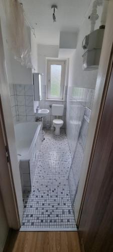 ein Badezimmer mit einem WC, einem Waschbecken und einer Badewanne in der Unterkunft Gästewohnung DGl in der Nähe zur Veltinsarena in Gelsenkirchen