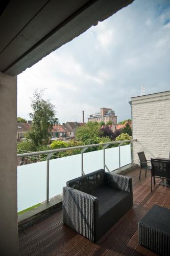 a patio with a couch and a table on a balcony at B&B Innbrugas in Bruges