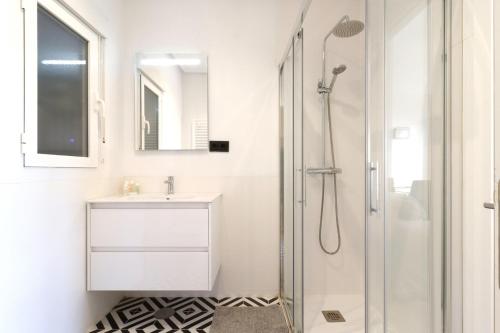 a white bathroom with a sink and a shower at Alojamientos con encanto a orillas del Manzanares in Madrid