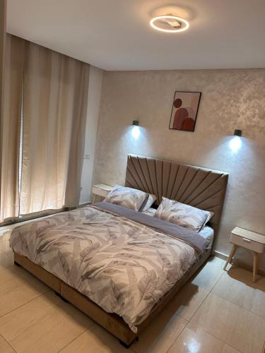een slaapkamer met een groot bed en een bedframe bij Appartement vue sur Mer Sidi Bouzid in Moulay Abdallah