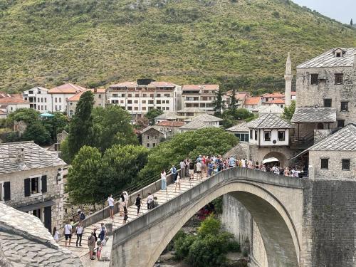 a group of people crossing a bridge over a city at Captain's Luxury Apartments in Mostar