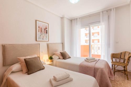 ein Schlafzimmer mit zwei Betten und einem Fenster in der Unterkunft VISTAS A DOS MARES La Manga del Mar Menor KM10 ISLA GROSA 2dormitorios in La Manga del Mar Menor