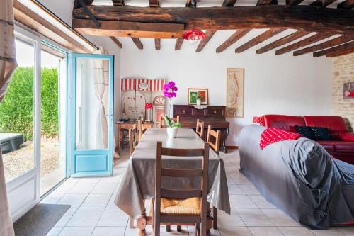 un salon avec une table et un canapé dans l'établissement Maison de campagne au cœur de l'Auxois - Tivauche-le-Haut en Côte d'Or, à Corsaint