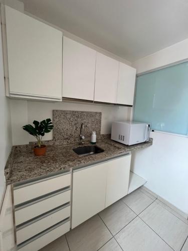 una cocina con armarios blancos y fregadero en Hostel Caminho do Mar en Florianópolis