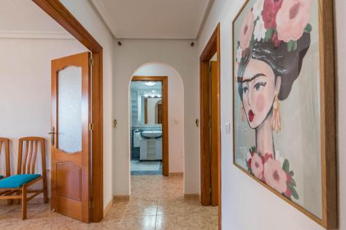 un corridoio con un dipinto di una donna sul muro di VISTAS A DOS MARES La Manga del Mar Menor KM10 ISLA GROSA 2dormitorios a La Manga del Mar Menor