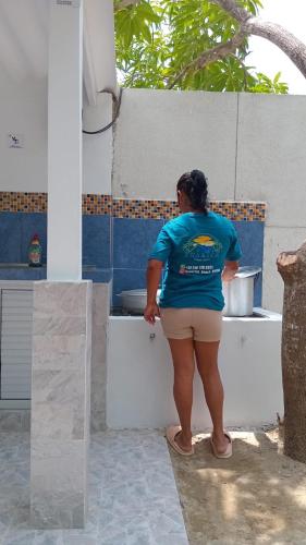 a woman in a blue shirt standing in a kitchen at Sharick Beach House in Tubará
