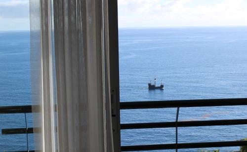 una finestra con vista su una barca nell'oceano di Sea Front House a Funchal