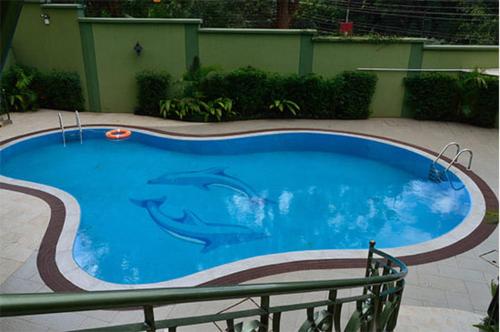 a swimming pool with a dolphin painted on it at Westland's Gardens Suites One in Nairobi