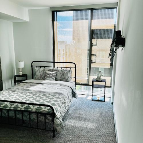 ein Schlafzimmer mit einem Bett und einem großen Fenster in der Unterkunft Hollywood Luxury Stay & FREE PARKING in Los Angeles