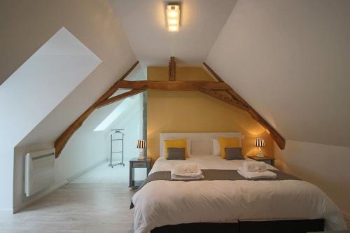 - une chambre mansardée avec un grand lit dans l'établissement Arnage Corner Lodge Piscine 20pers, à Moncé-en-Belin