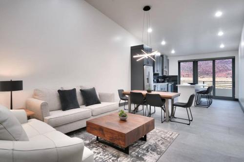 a living room with a white couch and a table at Vizcaya #1 - Moab's Newest Luxury Rental (Hot Tub) in Moab