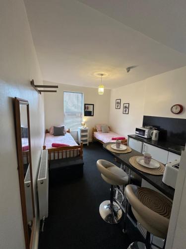 Habitación con 2 camas, mesa y sillas en Winter Gardens Flat 2 - Studio en Blackpool