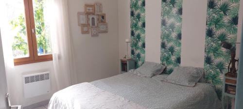 a bedroom with a bed with a tropical wallpaper at Villa 80 m2 jardin terrasse 3 chambres Provence in Volx