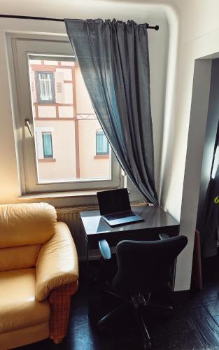 a desk with a laptop on it next to a window at NEW人 Dachterrasse PRIME/TV 人 4min zum Bhf in Kornwestheim