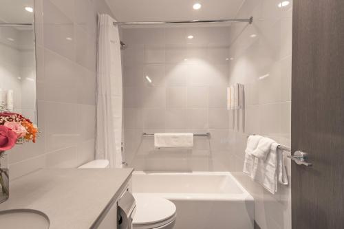 The Melrose Hotel في برونكس: حمام أبيض مع حوض ومرحاض