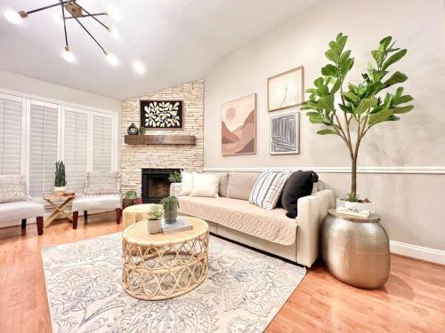 a living room with a couch and a tree in it at Comfortable Sleep 08 - Furnished Family Home with Spacious Backyard & Swing in Katy