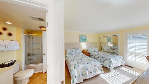 a bedroom with two beds and a bath tub at Lakeside Retreat in Gated Litchfield by the Sea in Pawleys Island
