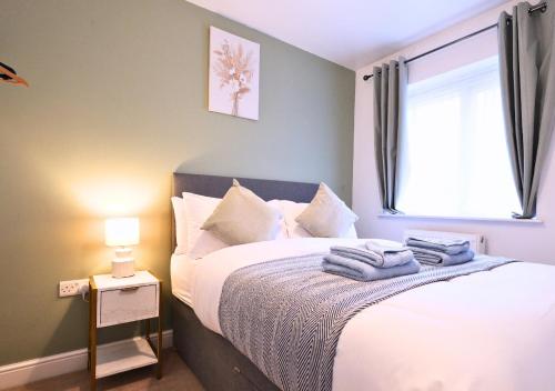 a bedroom with a bed with towels on it at Central Getaway House with Parking, Garden, Wi-Fi in Stafford