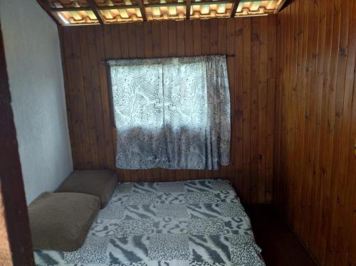 a small bedroom with a bed and a window at CASA TO Patrao LUXO in Itapecerica da Serra