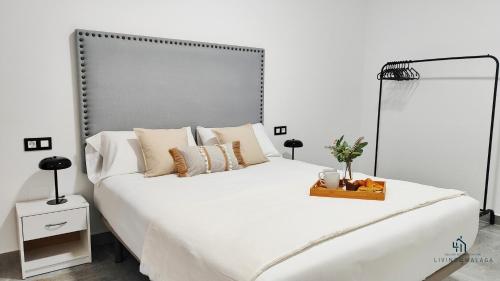 a bedroom with a large white bed with a metal headboard at Living4malaga Victoria Center Apartment in Málaga