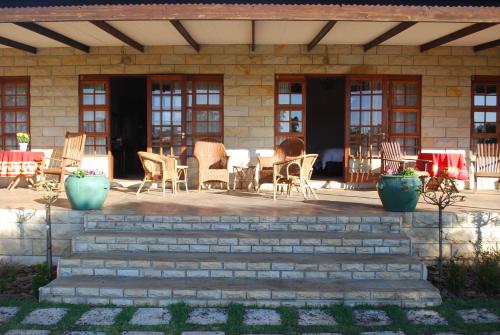 a patio with chairs and a table and chairs at Olive Hill Country Lodge in Bloemfontein