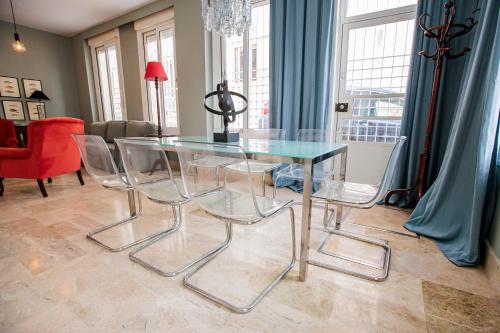 uma mesa de vidro e cadeiras numa sala de estar em Apartamento Arrayan em Sevilha